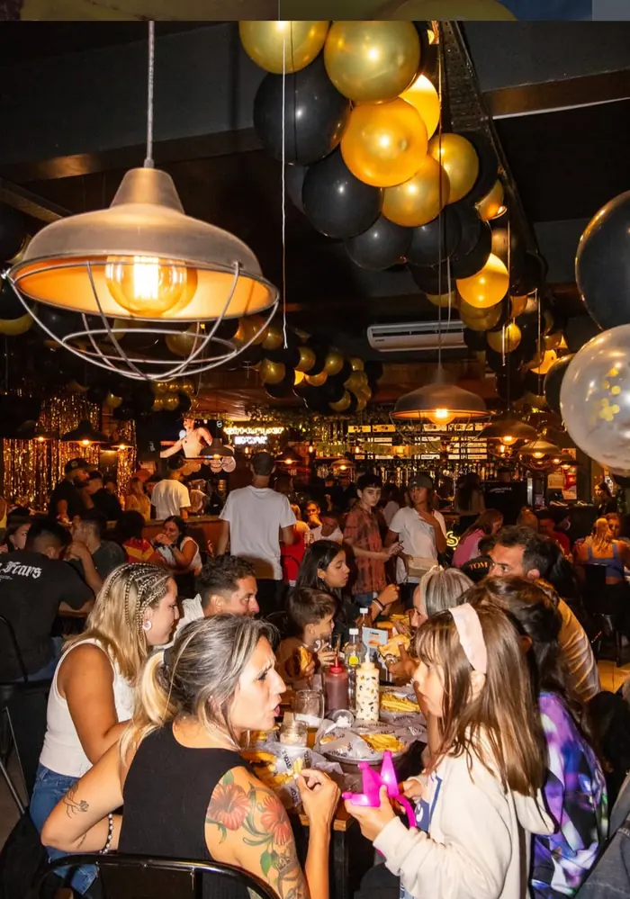 El salón completo, con globos negros y dorados colgados del techo y todas las mesas ocupadas.